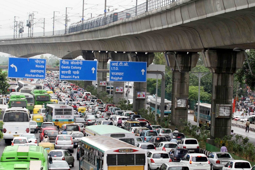 Buses, cars and motorcycles sit bumper to bumper in traffic on a busy road in the Indian capital.
