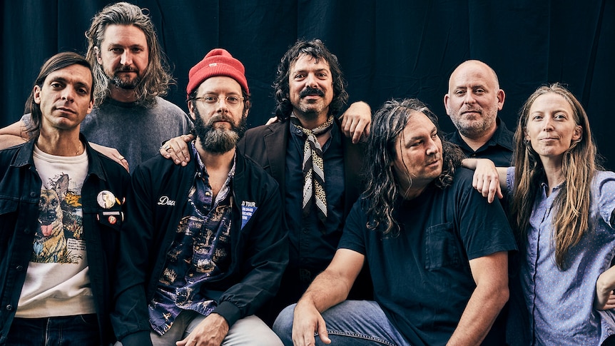 Seven members of The War On Drugs pose for a group photo.