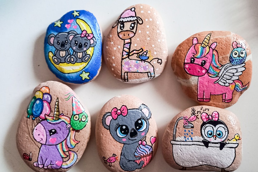 Six painted rocks depict cartoon characters