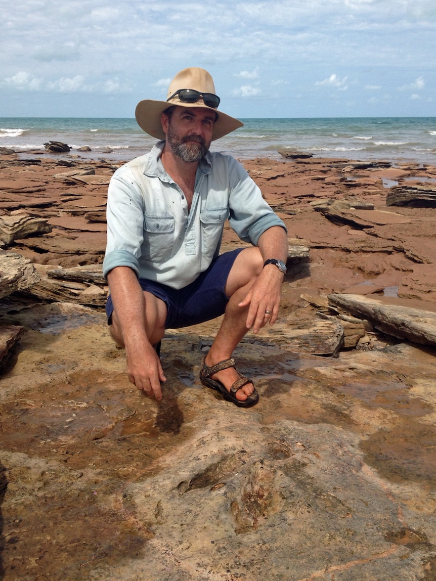 Dr Steve Salisbury next to a dinosaur footprint on Broome's Riddell Beach.