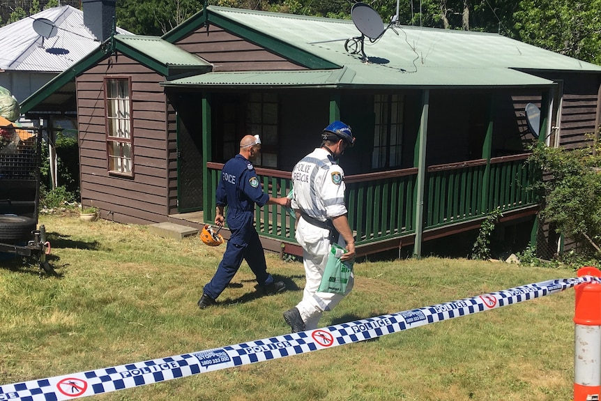 Two police officers in the backyard of a Blue Mountains property.