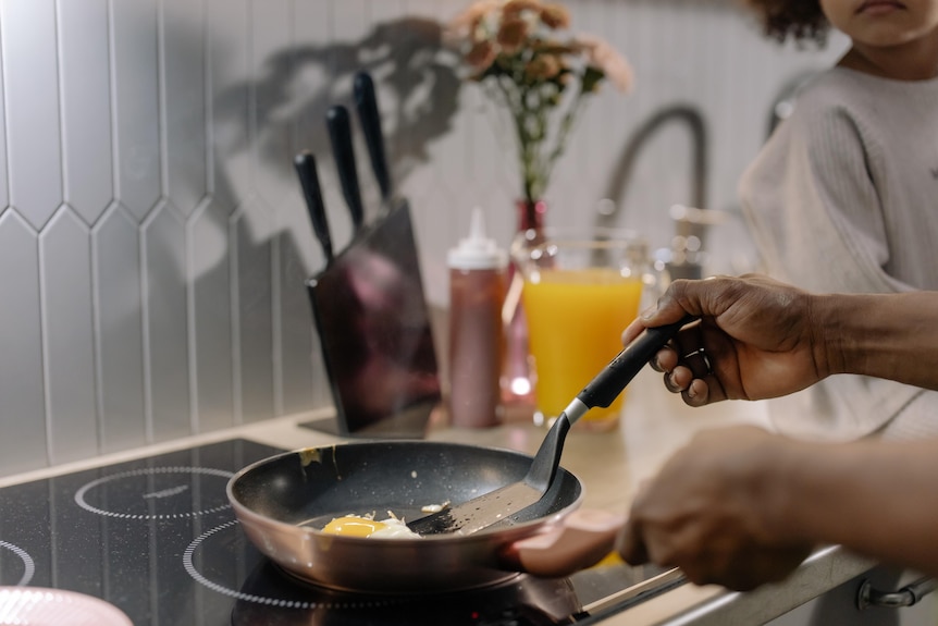 Person cooking egg on induction cooktop