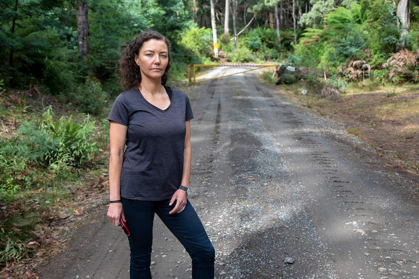 A woman standing in a forest.