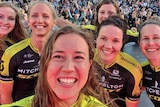 Six smiling women cyclists.