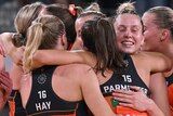 A group of GWS Giants players hug each other on the court