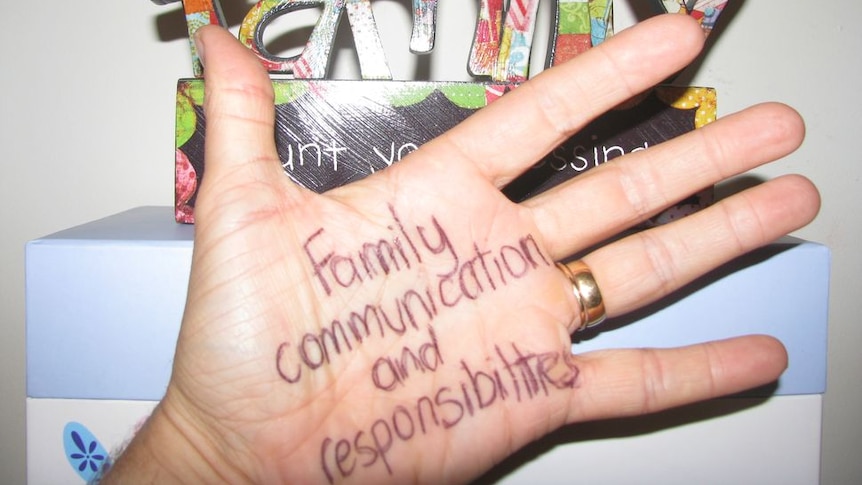 Open hand with family communication and responsibilities written in pen