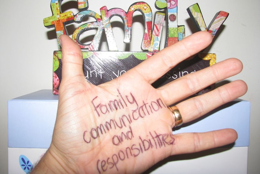 Open hand with family communication and responsibilities written in pen