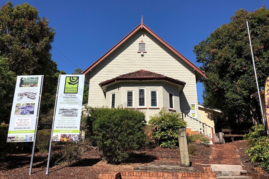 A timber church building with signage out the front.