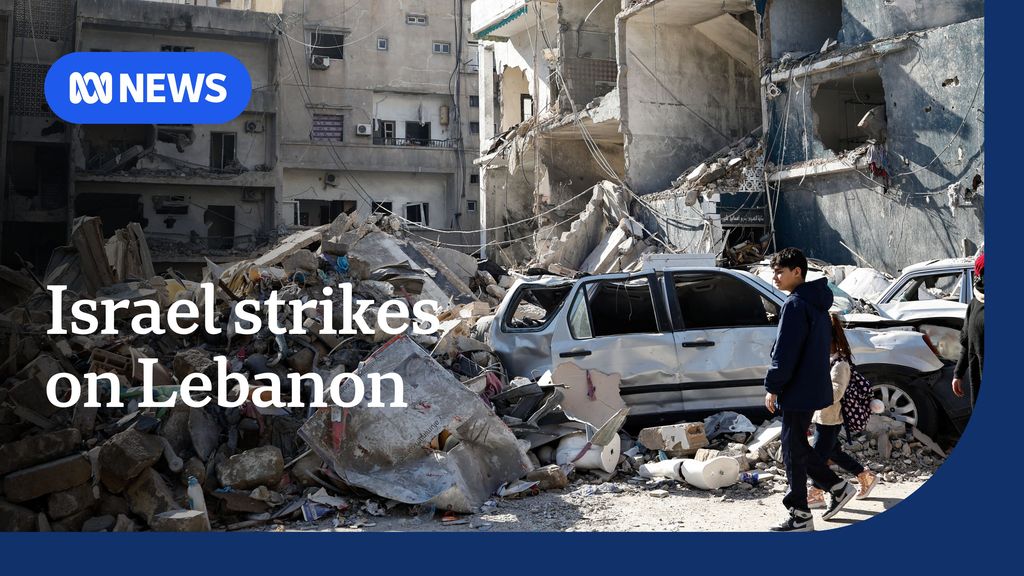 Israel strikes on Lebanon: A boy an girl walk in front of a building that's been reduced to rubble.