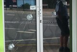 Four bullet holes in the front door of the tattoo parlour on the Gold Coast.