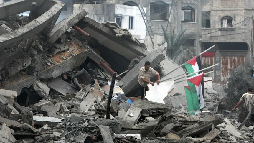 Palestinians inspect the destroyed office building of Hamas prime minister Ismail Haniya