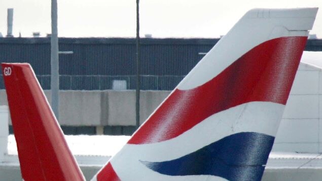 A Qantas plane passes in front of a British Airways plane