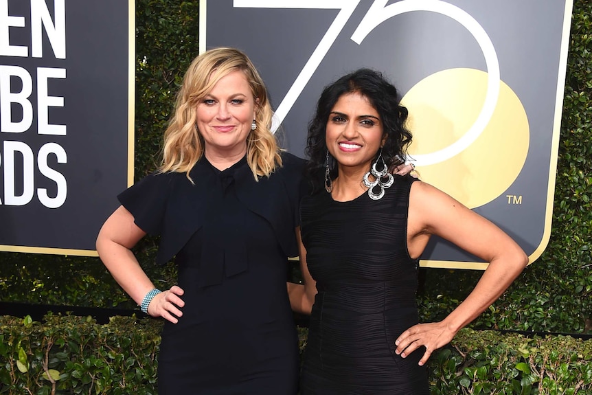 Amy Poehler, left, and Saru Jayaraman pose on the red carpet