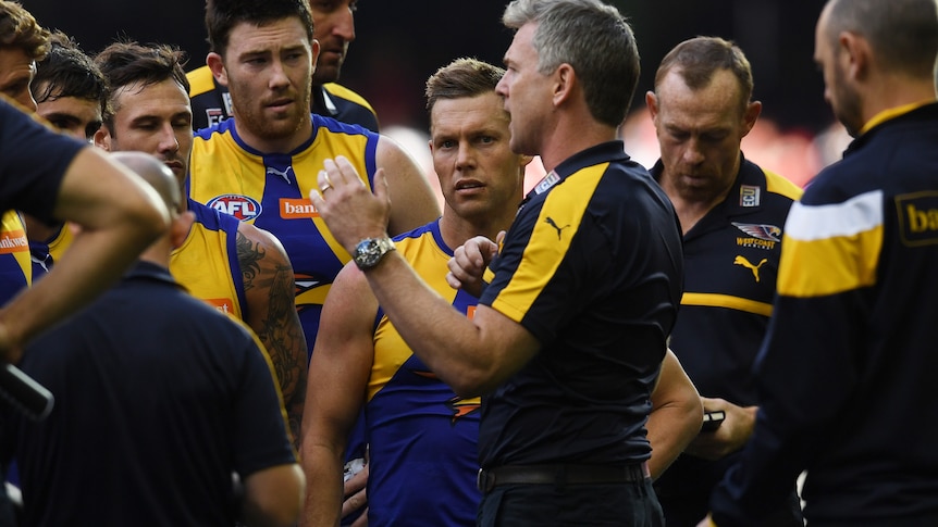 Sam Mitchell and his West Coast Eagles teammates listen to coach Adam Simpson in a team huddle at Docklands Stadium.