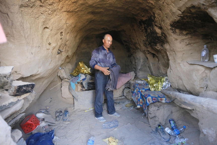 A man stands in a cave.