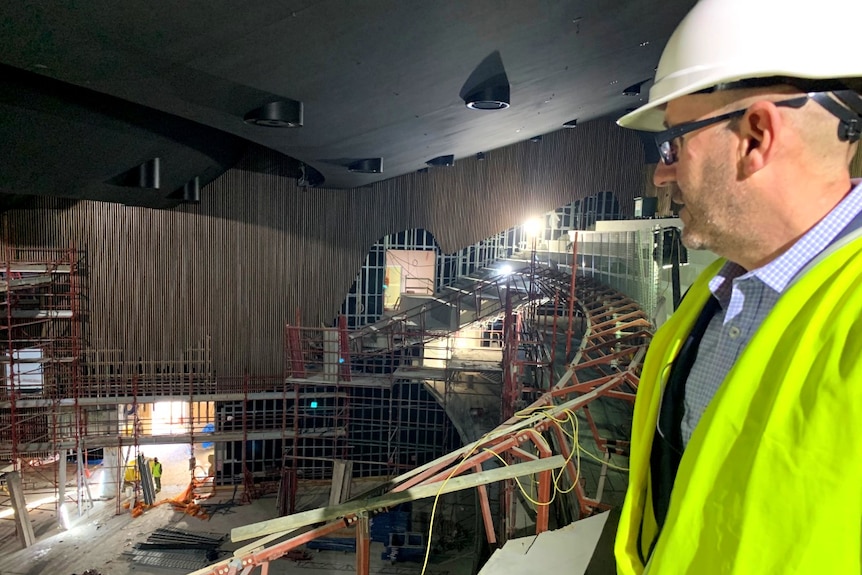 A man looks over the interior of a building site.