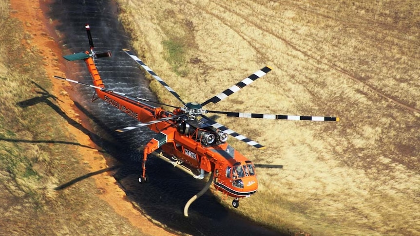 Helicopter picks up water during bushfires