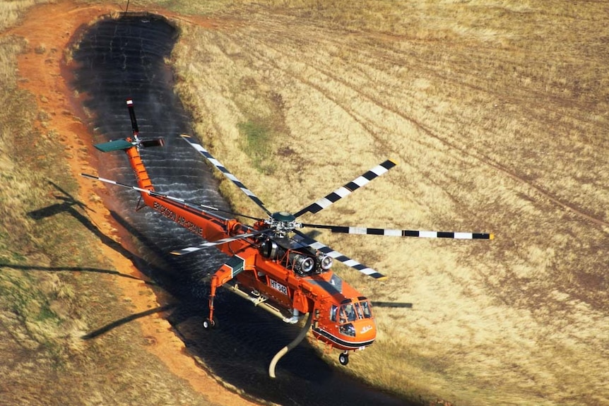 Helicopter picks up water during bushfires