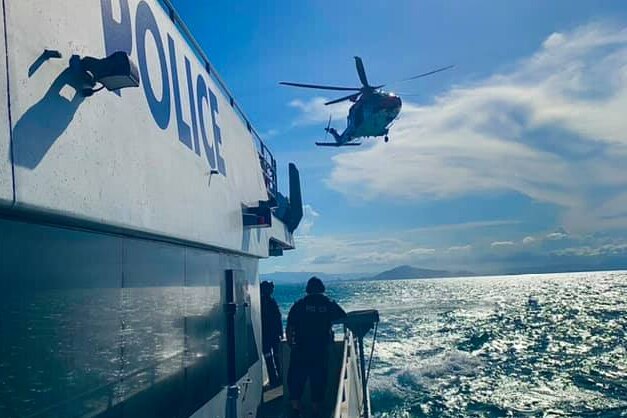 Police helicopter over water, photo taken from police boat
