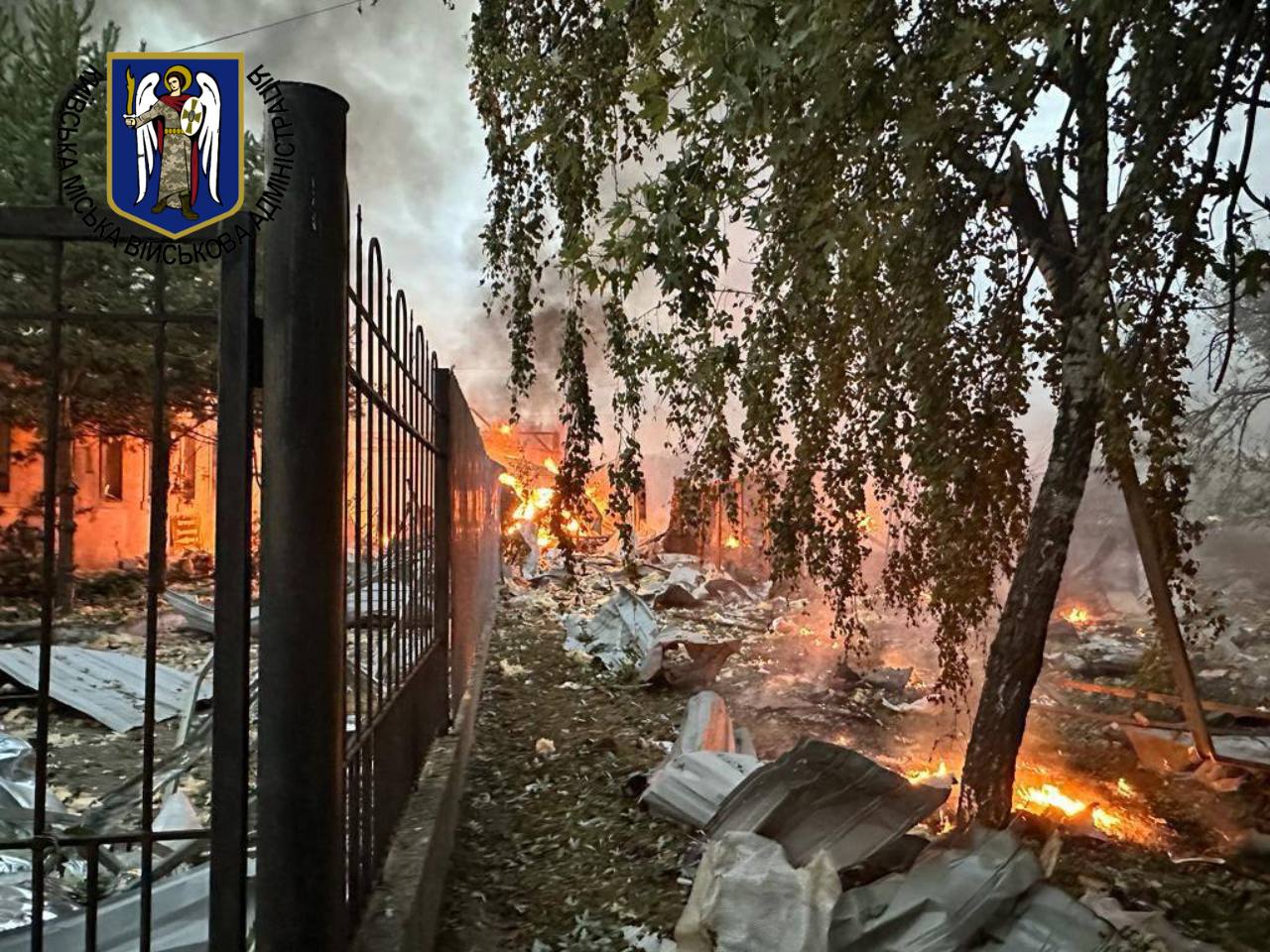 photo of fire and debris next to fence 