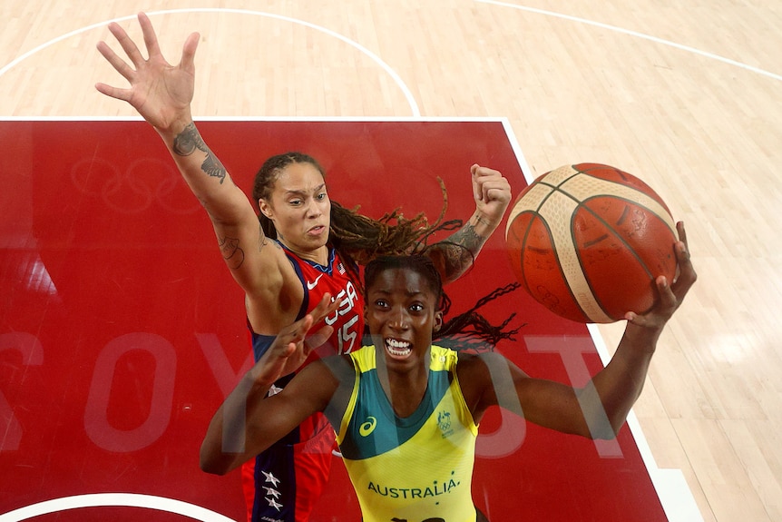 Australia basketball player Ezi Magbegor tries to lay the ball in as USA's Brittney Griner tries to block her shot from behind.