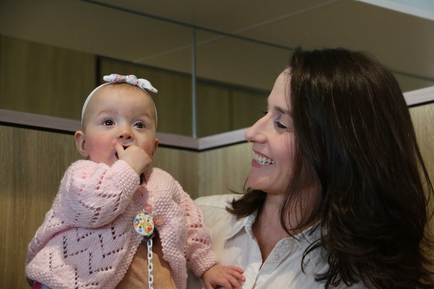 A mother holds her baby daughter.