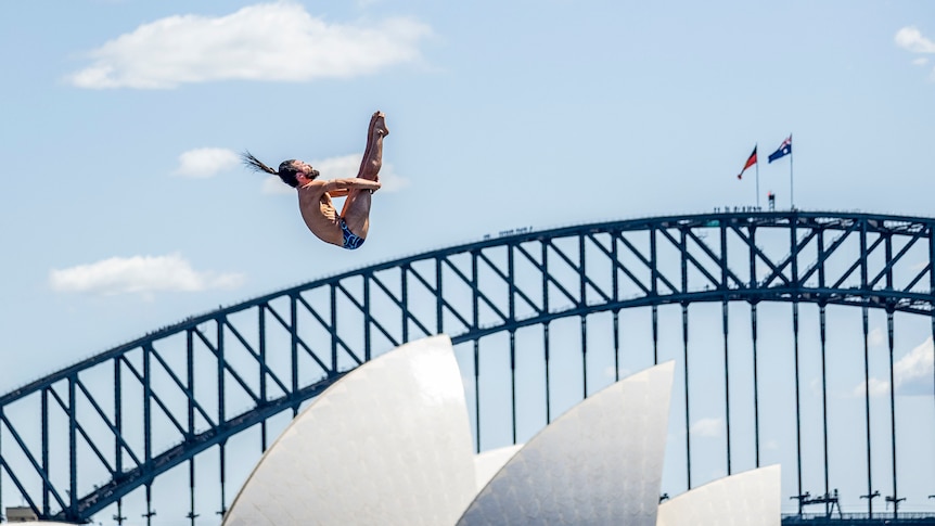 Catalin Preda dives in front of the Harbour Bridge and Opera House