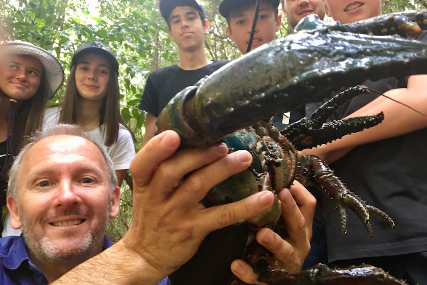 Bioblitz volunteers pose with the crayfish