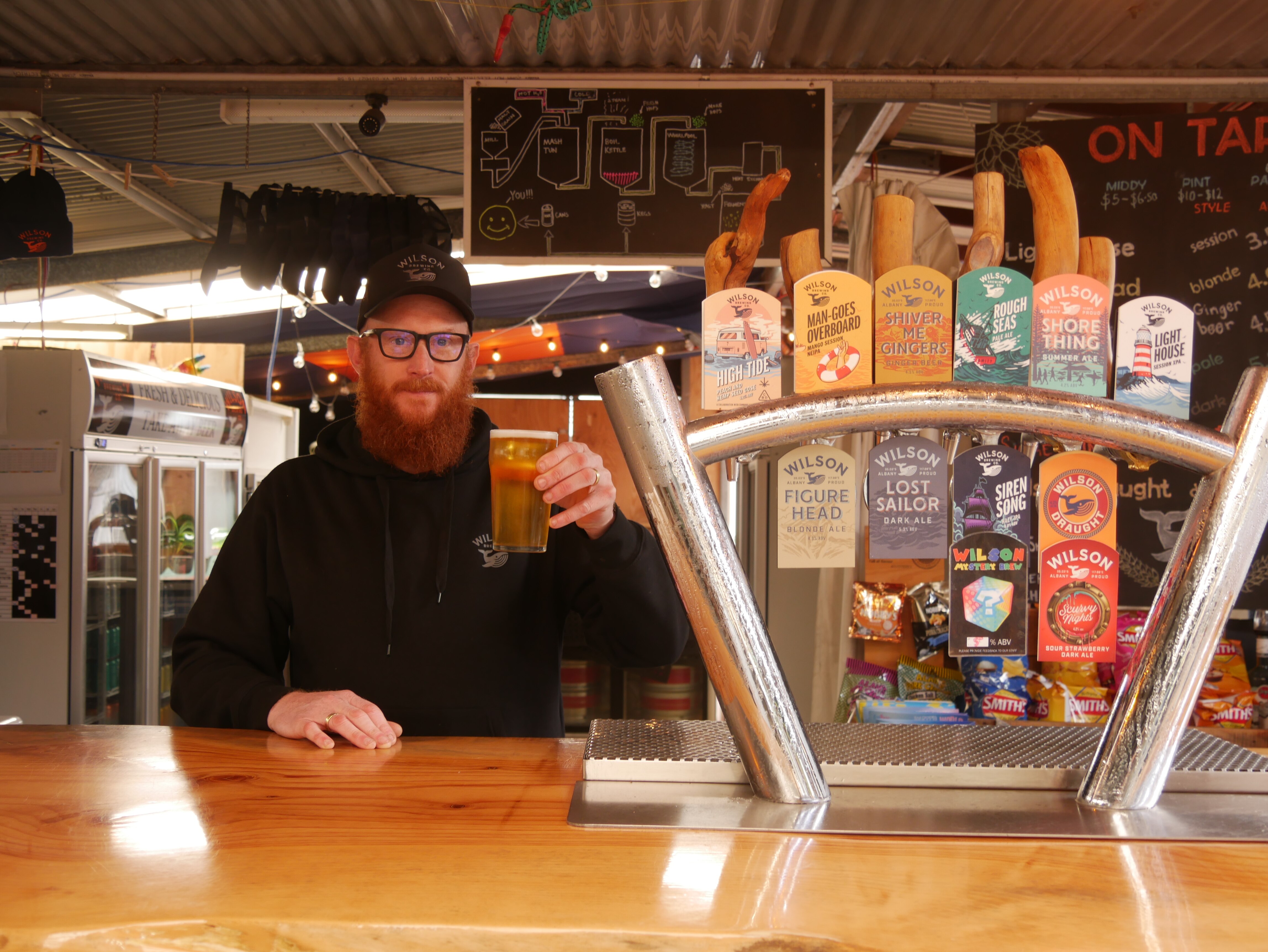 Man behind bar at the pub with a beer
