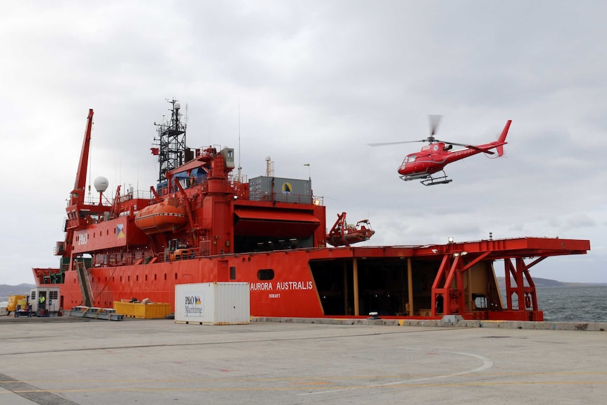 A helicopter lands on the Aurora Australis as the icebreaker prepares to depart for the 2015/16 summer research season