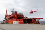 A helicopter lands on the Aurora Australis as the icebreaker prepares to depart for the 2015/16 summer research season