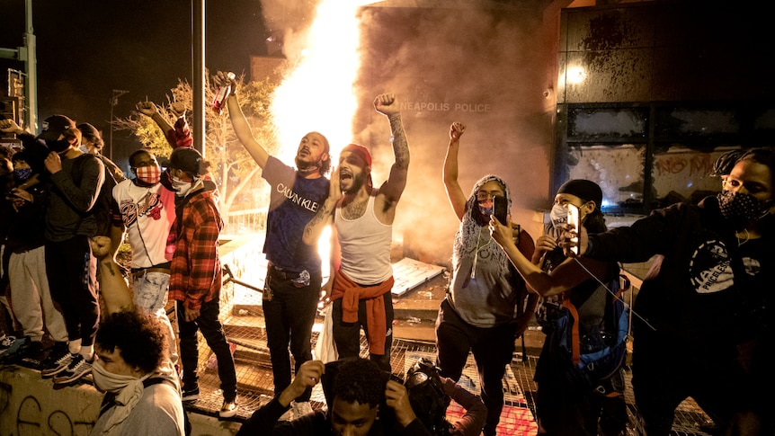 Protesters celebrate setting a police station on fire in Minneapolis.