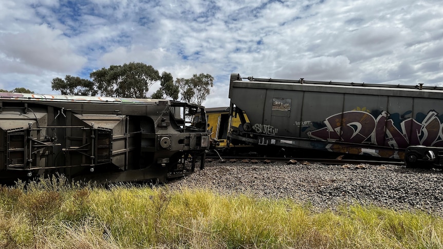 Train carriages and an engine sit askew from a rail line in regional NSW. 
