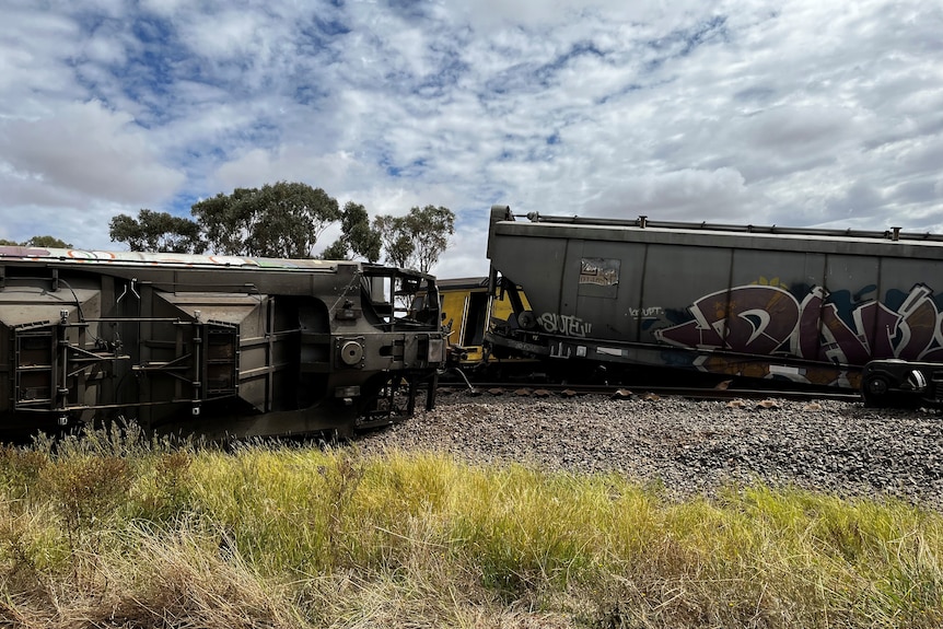 Train carriages and an engine sit askew from a rail line in regional NSW. 