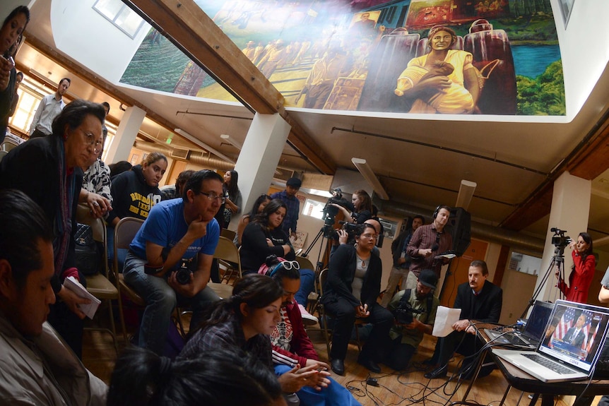 Activists at the Central American Resource Centre in Los Angeles watch as Barack Obama delivers his immigration plan.