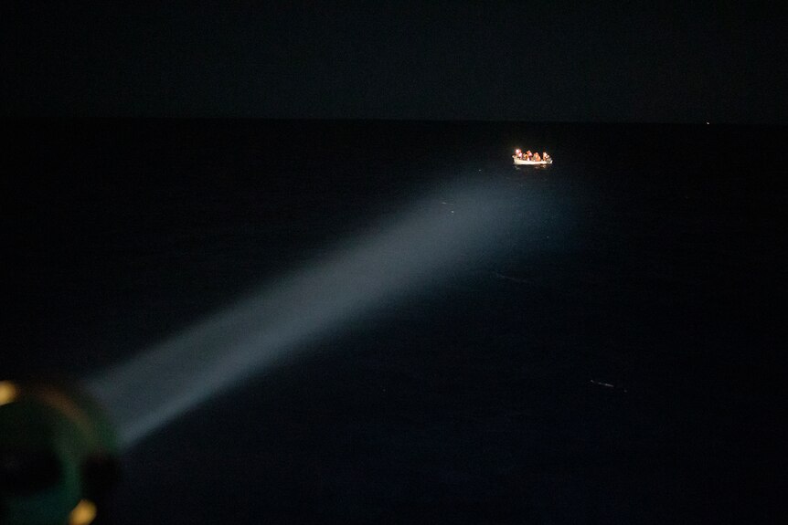 A migrant boat in the search spotlight.