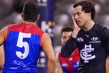 Cameron Polson holds his hand to his face in disappointment as Melbourne players celebrate