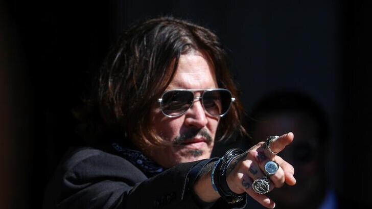 Actor Johnny Depp gestures as he arrives at the High Court in London, Britain.