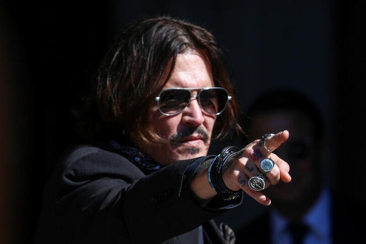 Actor Johnny Depp gestures as he arrives at the High Court in London, Britain.