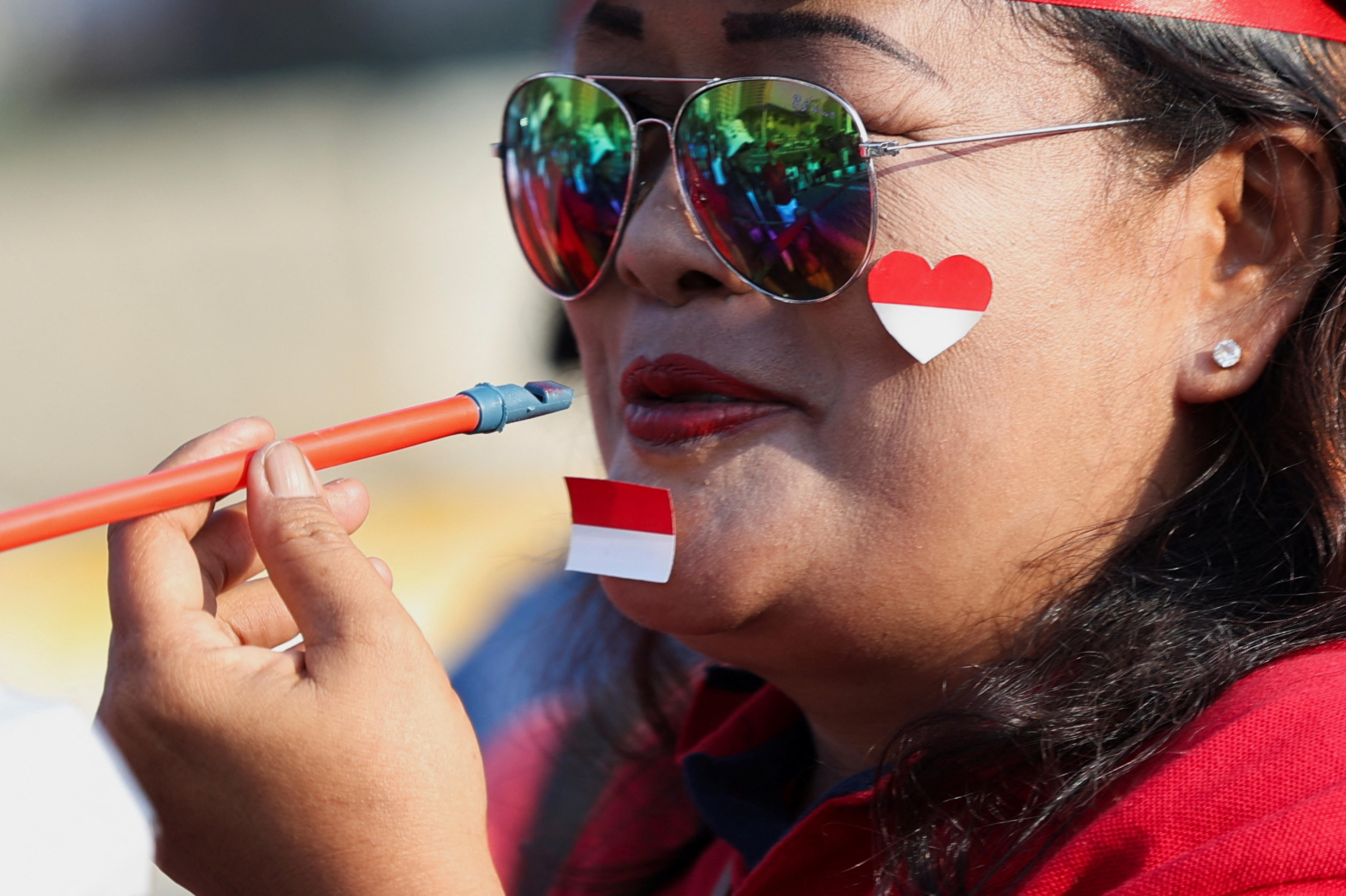 A woman with Indonesian flag sticker on her face