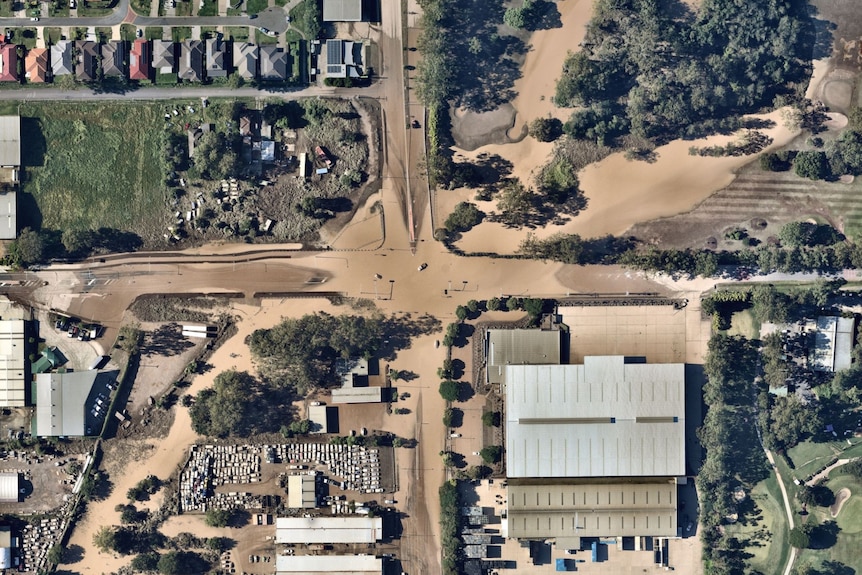 Aerial view of receding floodwaters at an intersection in a Brisbane suburb.