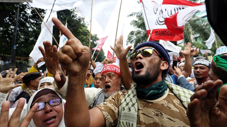Muslim protesters shout slogans during a protest against Jakarta's Christian Governor Basuki "Ahok" Tjahaja Purnama outside a court where his trial is held in Jakarta, Indonesia, Tuesday, May 9, 2017.