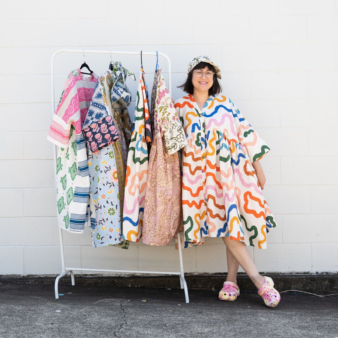 Sue-Ching Lascelles stands with some of her designs