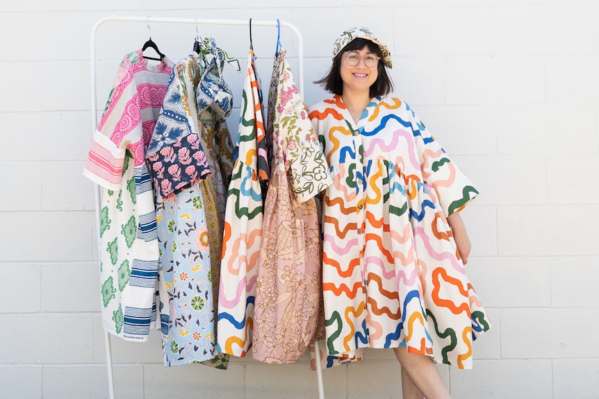 Sue-Ching Lascelles stands with some of her designs