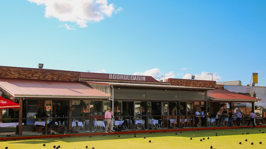 A man watching a lawn bowls game.