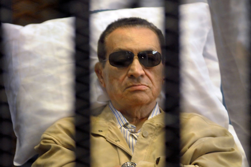 Ousted Egyptian president Hosni Mubarak sits inside a cage in a courtroom during his verdict