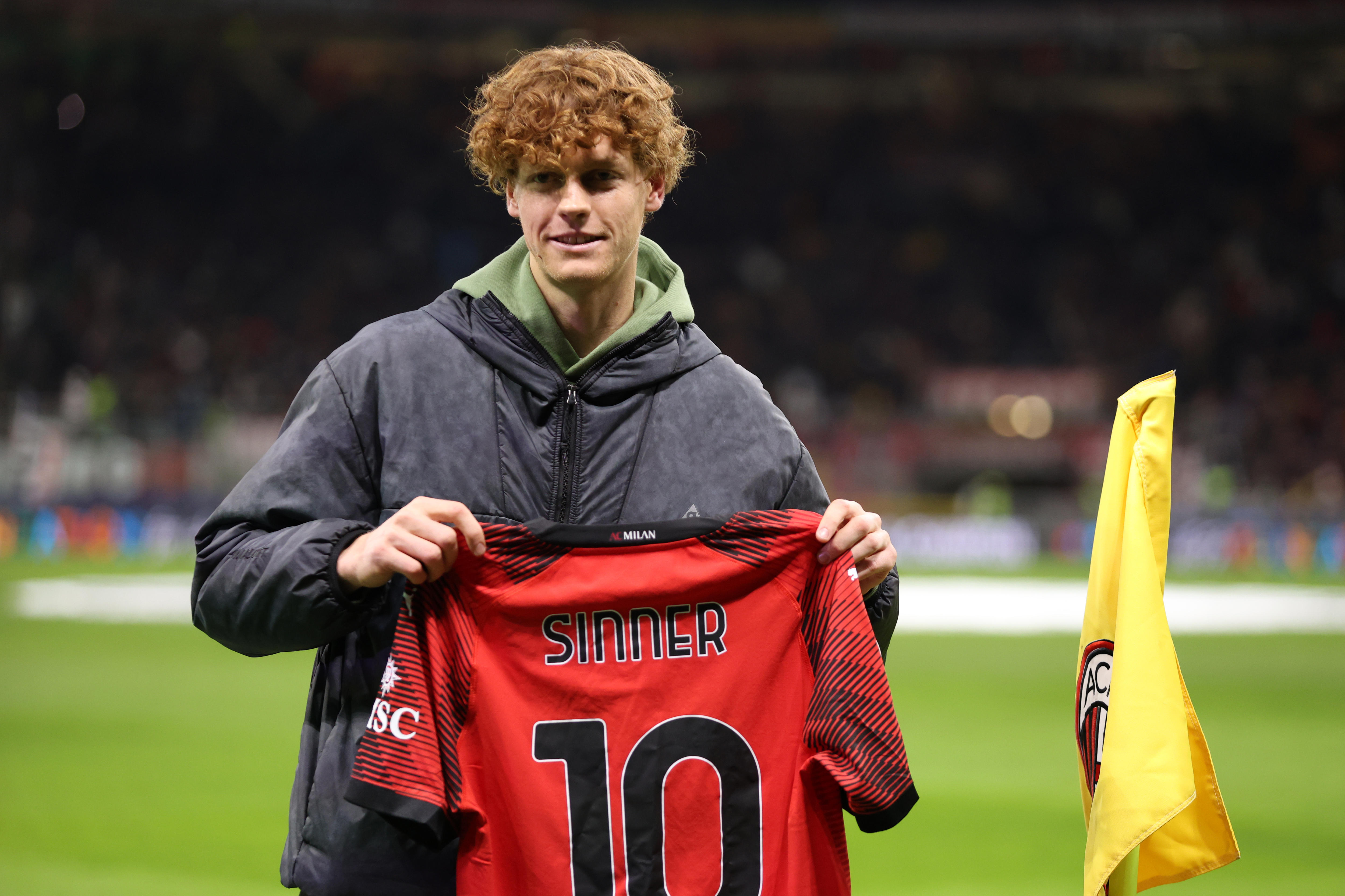 Jannik Sinner holds an AC Milan shirt