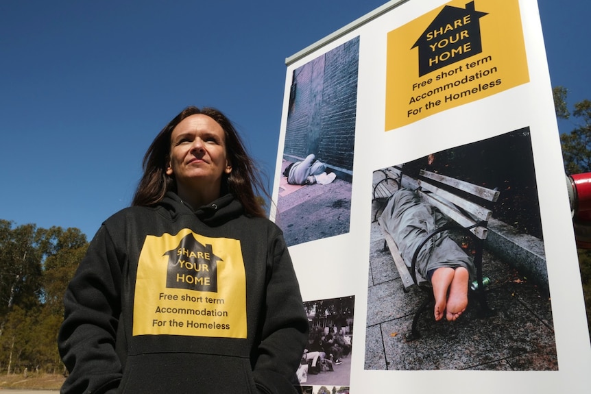 Woman looks into the sun wearing a Share Your Home jumper