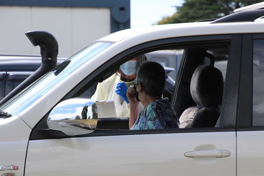 A woman gets a coronavirus test in her car.