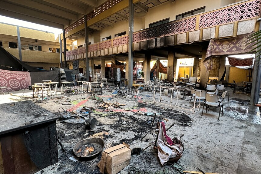 Damaged chairs and burnt debris in abandoned school 